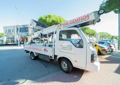 Camión con grúa de Los Gemelos en acción en el exterior, listo para la mudanza.