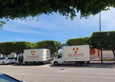 Camiones de Mudanzas y Guardamuebles Los Gemelos estacionados bajo árboles en el sur.