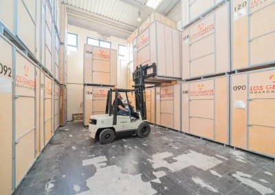 Operario de Los Gemelos utilizando montacargas para organizar cajas de almacenaje.